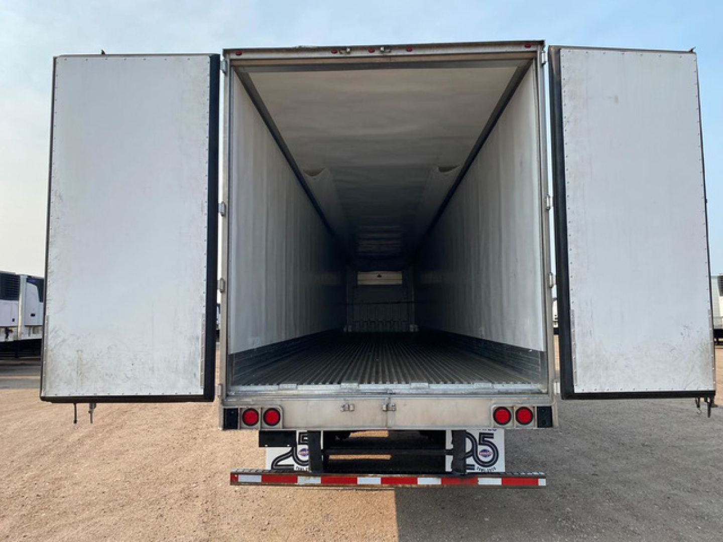 Trailer cargo area of a 2021 Utility Reefer showing open rear doors with empty interior and metal floor.
