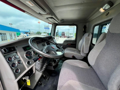 Kenworth T270 truck cab interior with steering wheel, dashboard gauges, and two front seats visible.