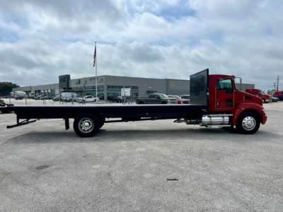 Kenworth T270 flatbed truck side view showing long flatbed with red cab and black chassis