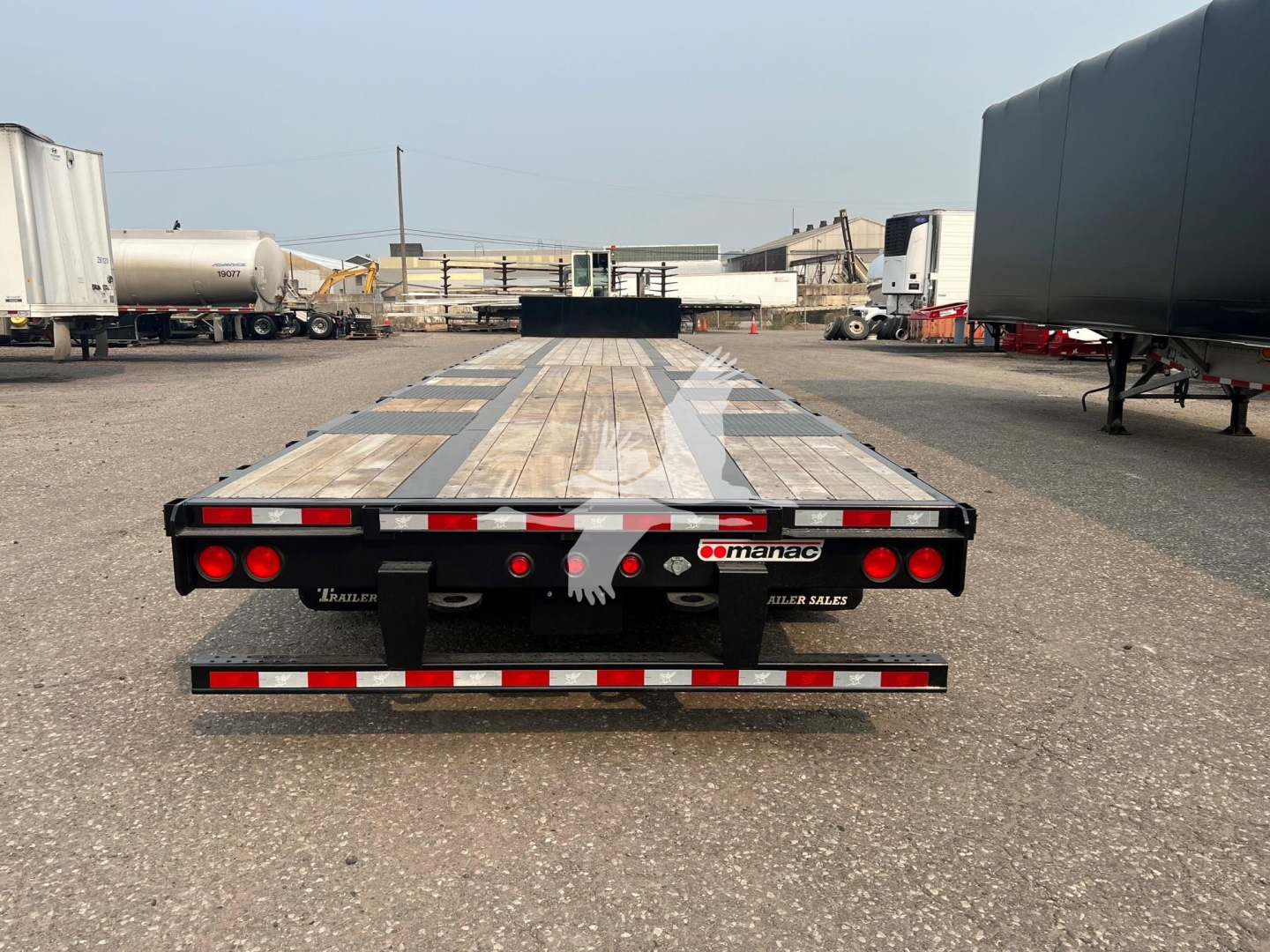 Manac drop deck extendable trailer rear view showing deck and taillights with Manac logo and Thru-Deck branding