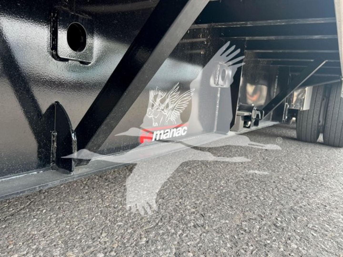 Manac steel drop extendable trailer underside with logo and support beams visible