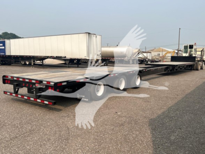 2023 Manac steel drop extendable trailer in a lot, low-angle view with extended deck and rear ramps.