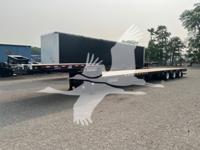 Manac steel drop extendable trailer with black gooseneck and long flat deck showing side decals and tandem axles.