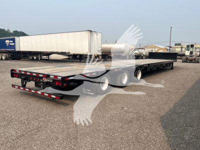 Flatbed trailer with extendable drop deck showing metal platform and rear taillights