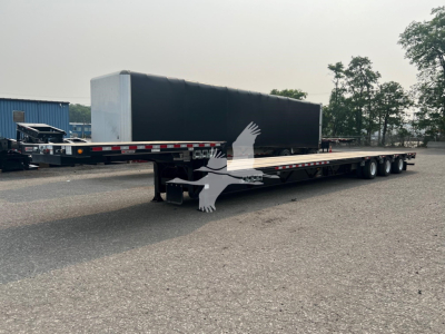 Manac steel drop extendable trailer in profile view showing long flatbed with extendable deck and tandem axles.
