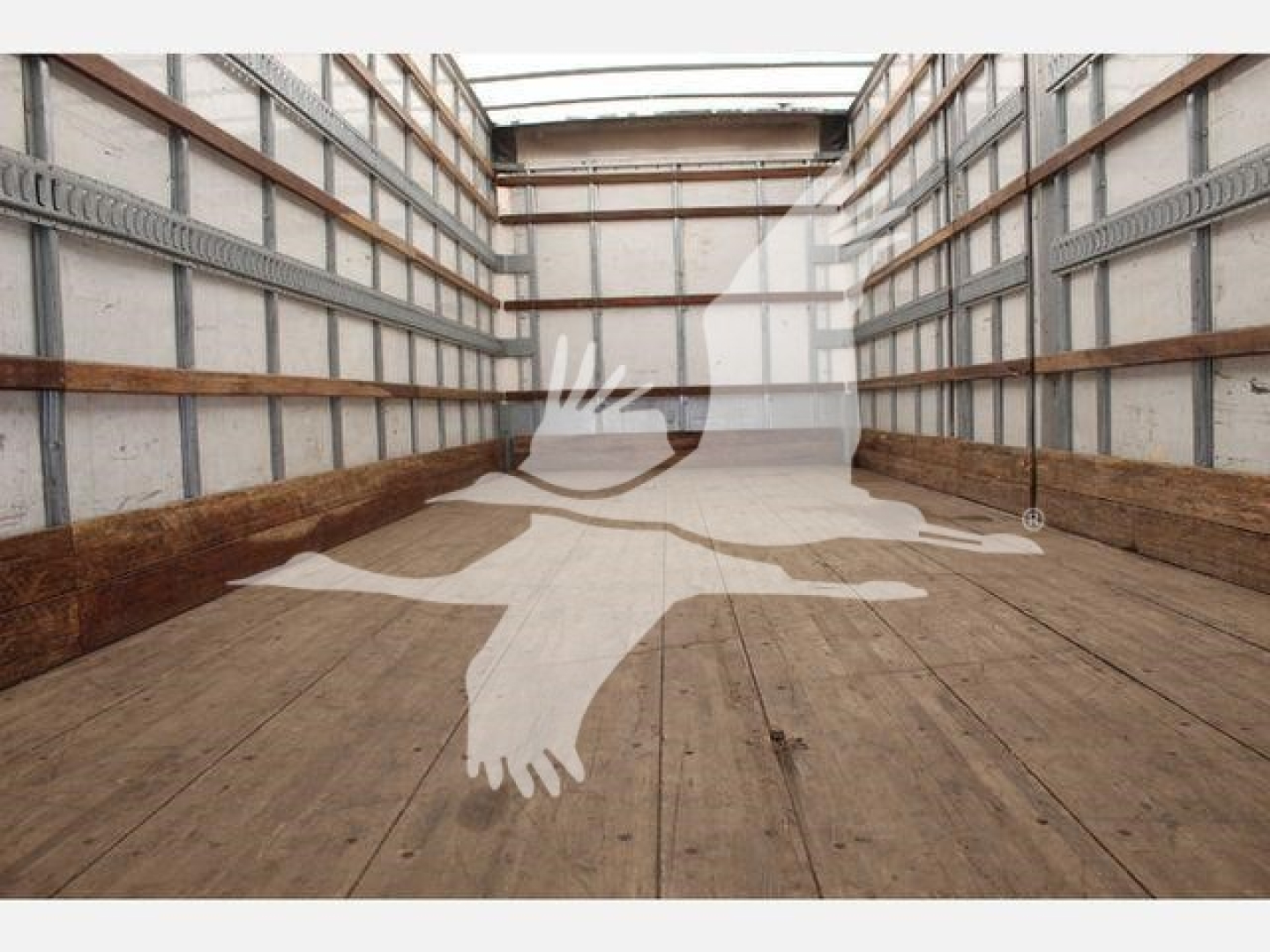 Truck trailer interior showing empty cargo space with wooden floor and metal side rails.