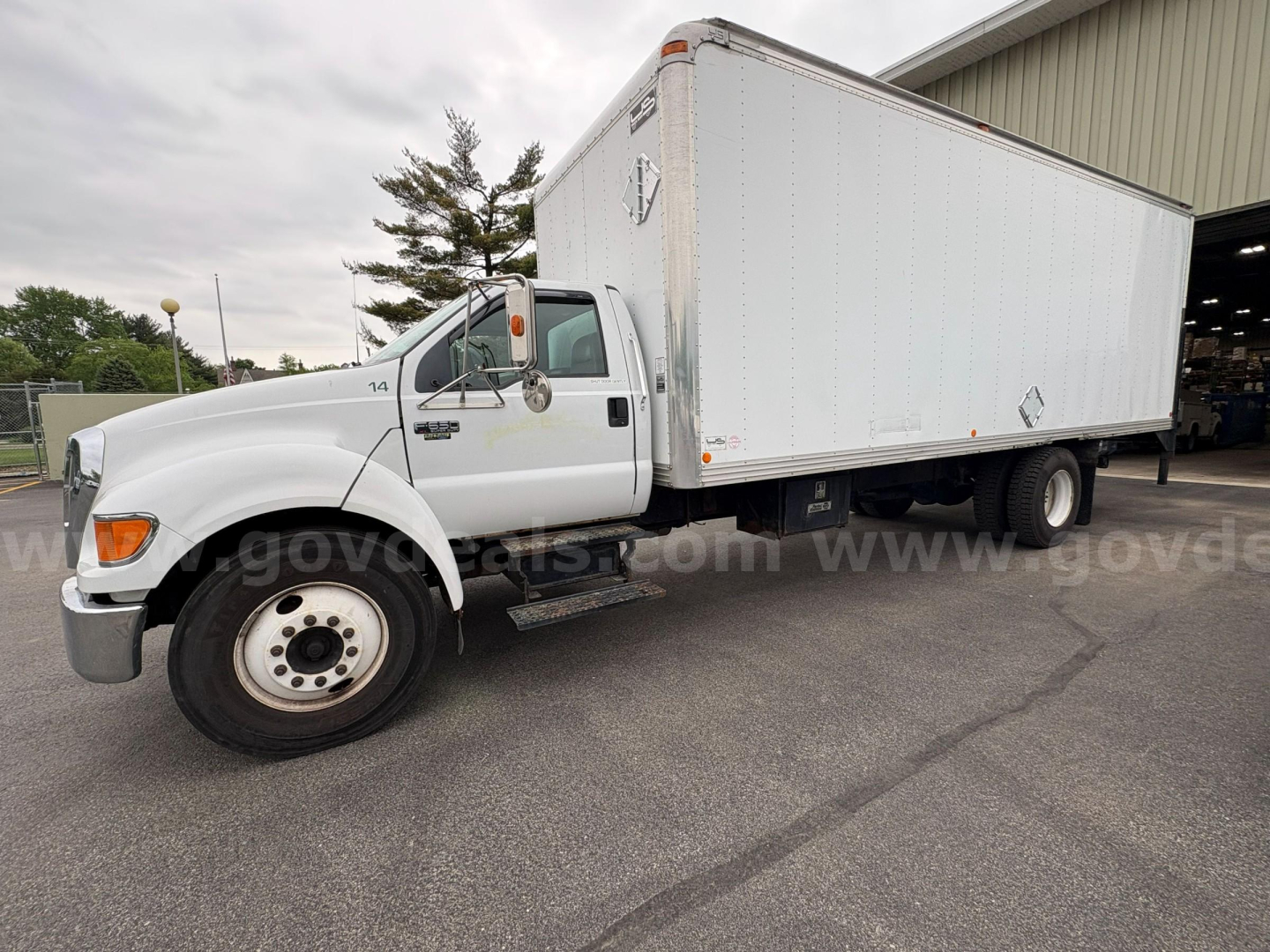 Box truck side view showing 2004 Ford F-650 with a large white cargo box and dual rear wheels.