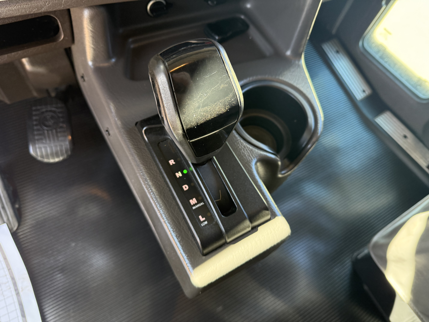 Kenworth W900L interior gear shifter area with center console and cup holder.