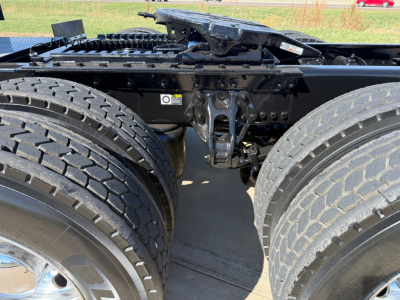 Kenworth W900L chassis with dual rear axles and fifth wheel, mid-section view showing drive tires and suspension components.