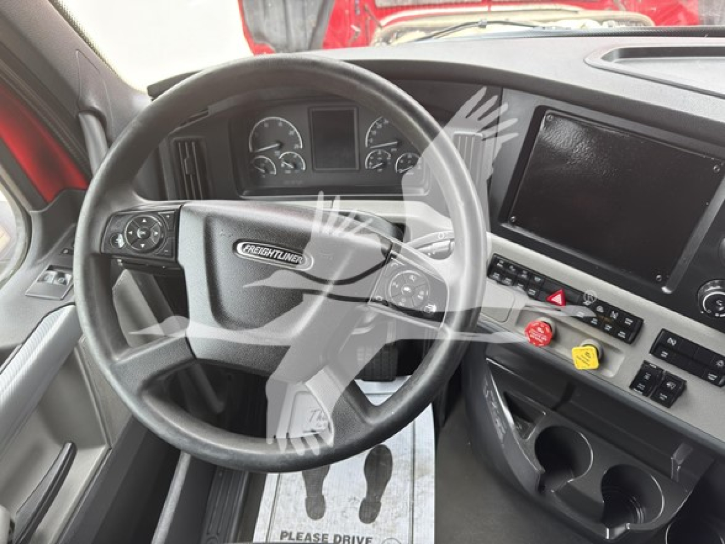 Freightliner Cascadia interior showing steering wheel, dashboard gauges, and infotainment touchscreen.