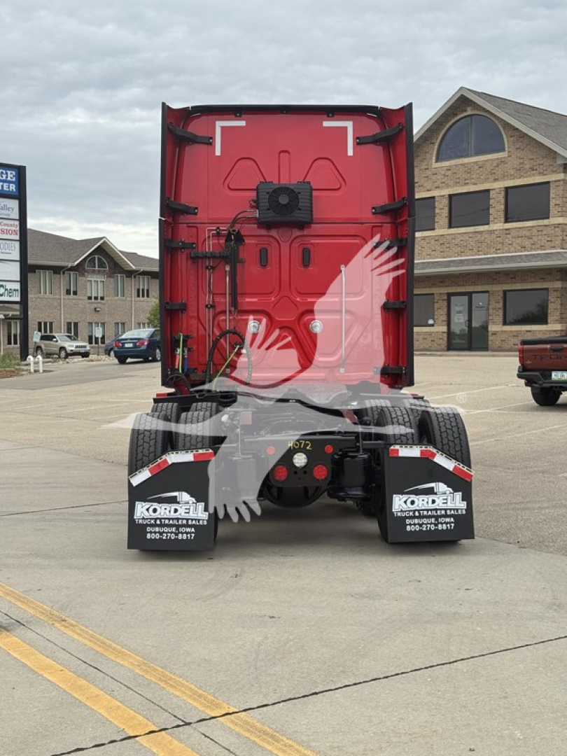 Freightliner Cascadia rear view showing truck sleeper with red back door and dual rear mud flaps; stock and dealer branding visible on mud flaps and surrounding area