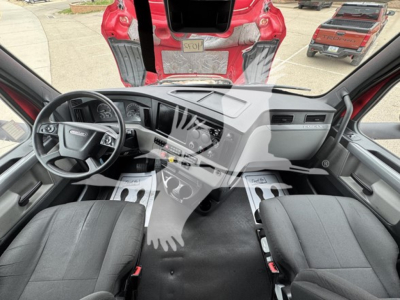Dashboard and front cabin view of a 2022 Freightliner Cascadia 126 sleeper cab showing steering wheel, center console, and driver/passenger seats.