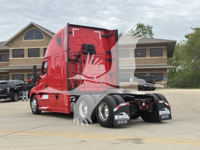 Truck tractor rear view showing dual rear axles with mud flaps, red sleeper cab, and dealership watermark. Visible text on mud flaps: 'Kobyl' and smaller lines.