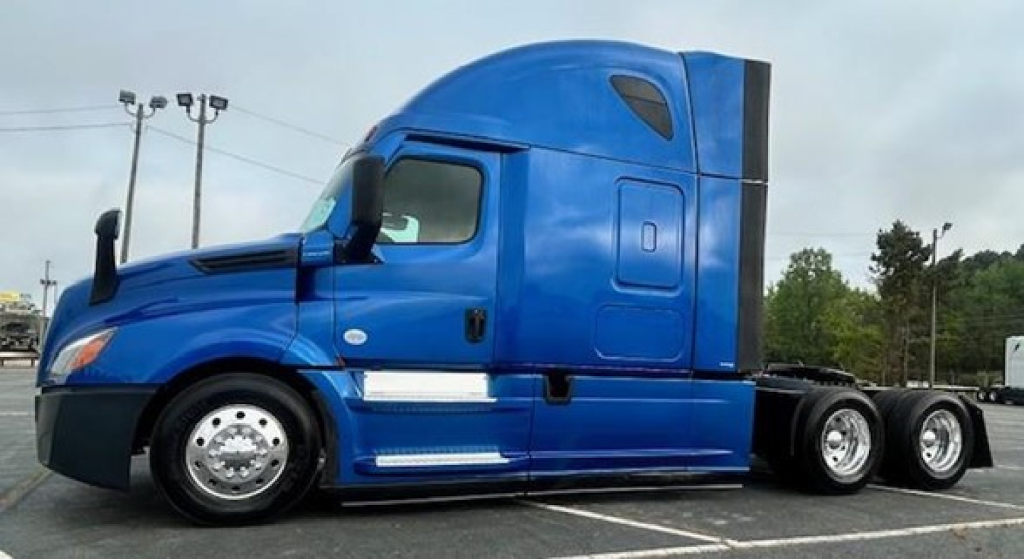 Truck cab side profile showing 2022 Freightliner Cascadia 126 with blue paint, sleeper cab, and chrome fuel tanks.