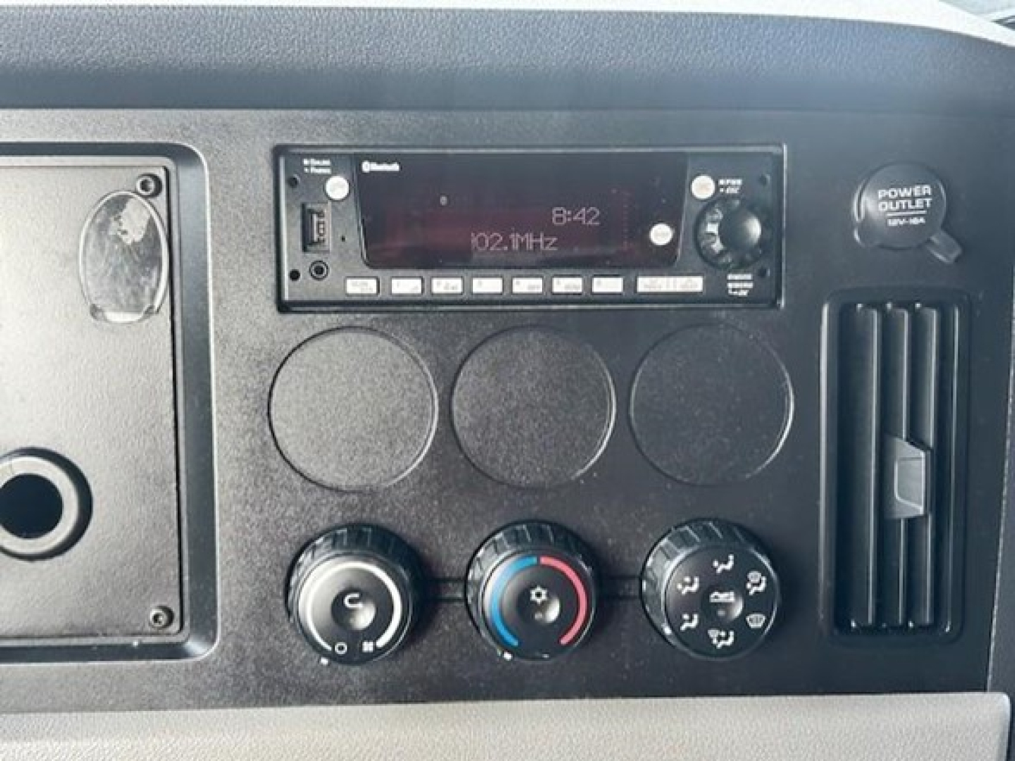 Dashboard panel of a 2022 Freightliner Cascadia 126 showing radio display and climate controls.
