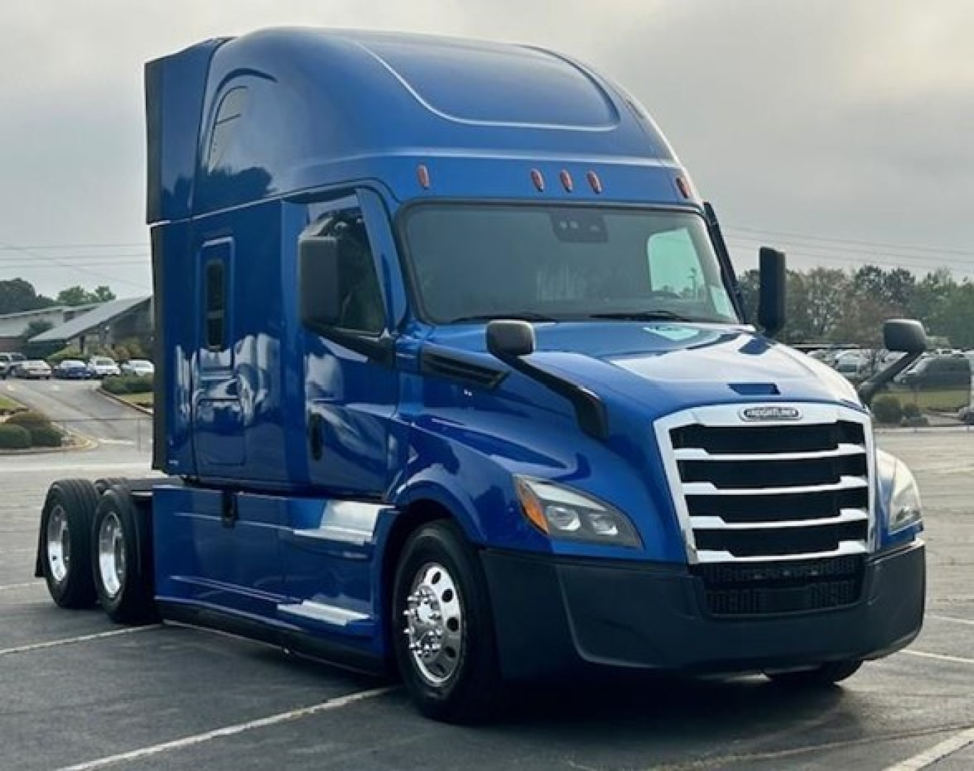 Freightliner Cascadia 126 sleeper tractor in blue, side view showing cab with aerodynamic mirrors and chrome grille.