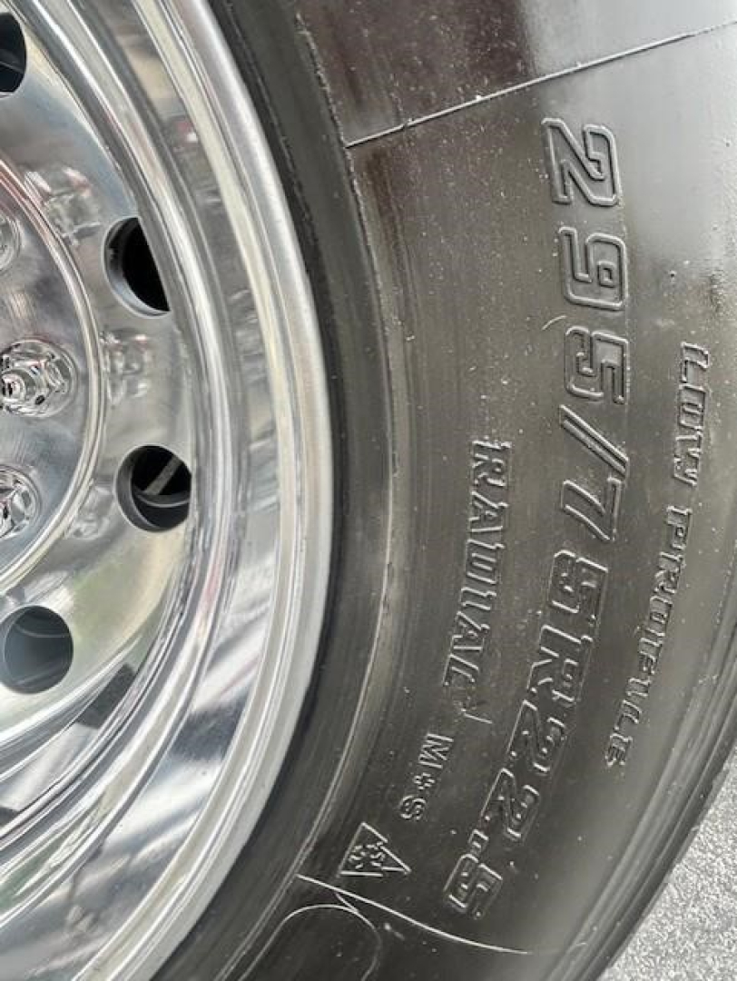 Wheel close-up of a Freightliner Cascadia 126 tire with embossed markings including weight and tire specs.