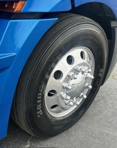 Freightliner Cascadia 126 front wheel showing dual rear outer tire, steel rim, and lug nuts.