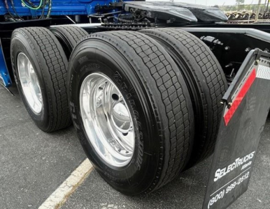 Freightliner Cascadia 126 rear dual-axle wheels with heavy-duty tires and chrome rims, part of a sleeper tractor chassis.