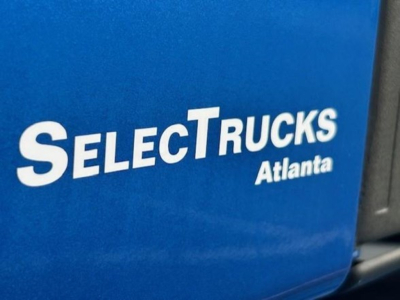 Truck cab side with blue SelectTrucks Atlanta logo visible near a Freightliner Cascadia 126 listing.