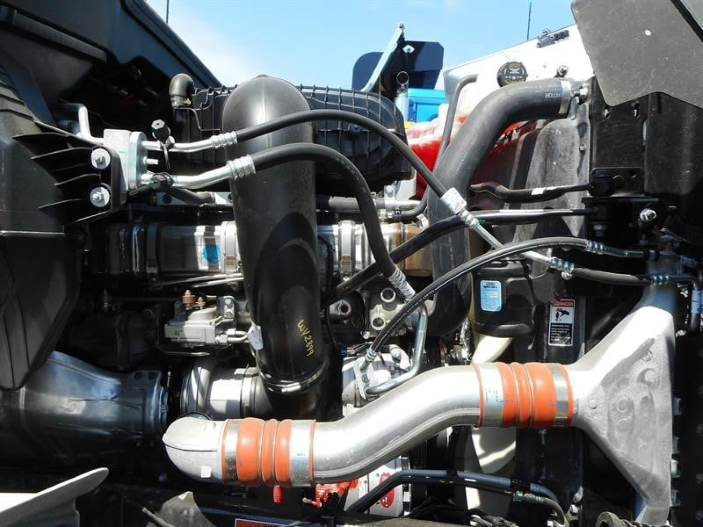 Western Star 49X engine bay showing intake piping, hoses, and intercooler tubing with orange silicone couplings.