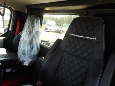 Interior of a new Western Star 49X day cab truck showing black quilted seat with Western Star logo and plastic-covered passenger seat.