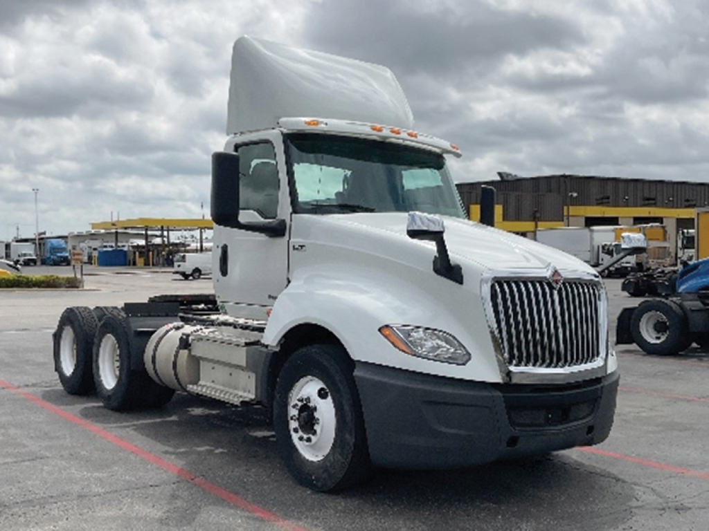 Truck cab and chassis showing International LT625 badge and front grille in a used truck lot.