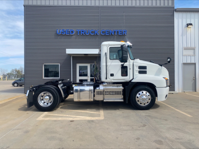 Truck chassis side view of a 2021 Mack AN42T conventional daycab in front of a Used Truck Center building.