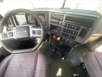 Dashboard and steering wheel of a 2021 Mack AN42T daycab truck interior with steering wheel, gauges, and center console controls.