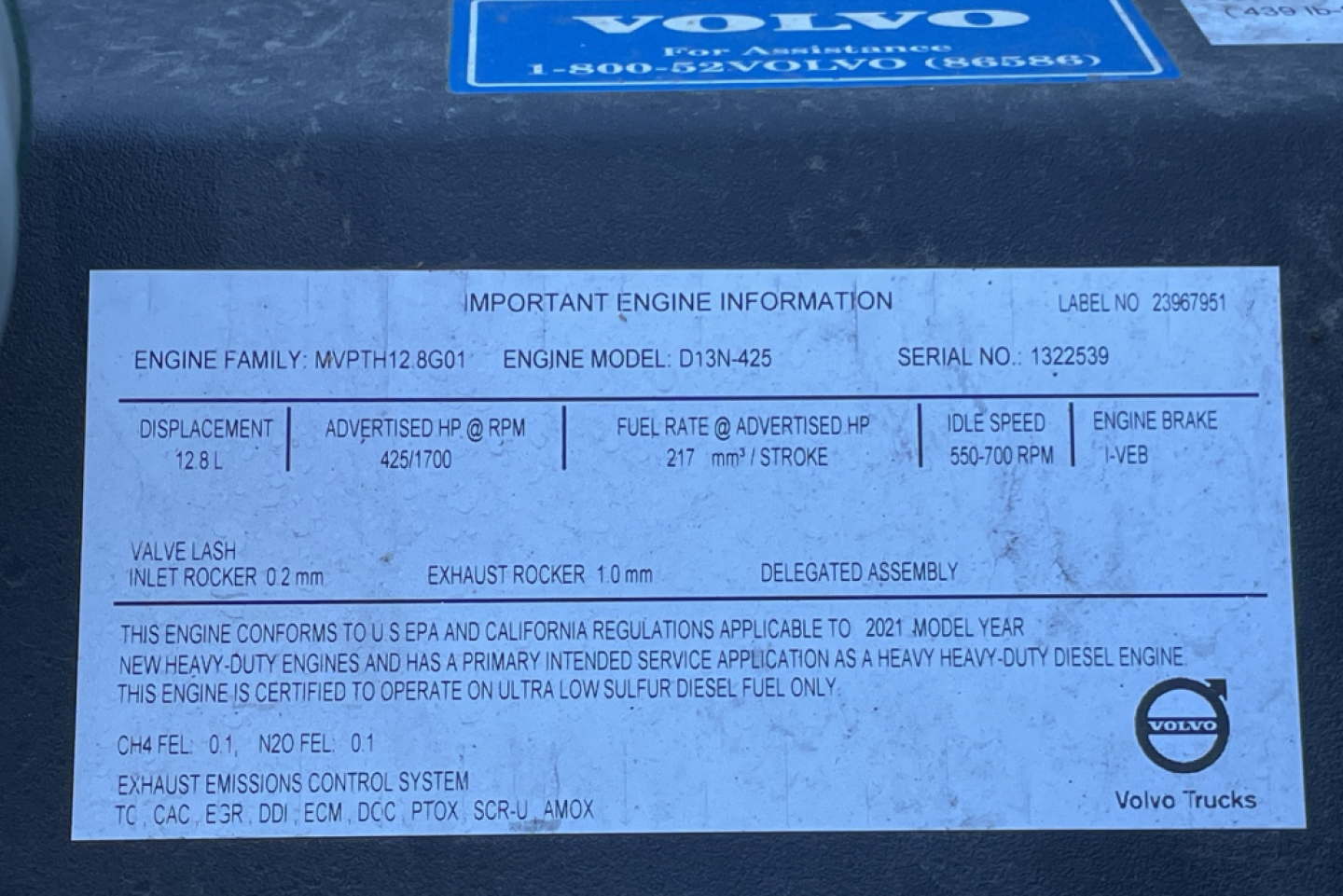 Engine information plate on Volvo D13 engine showing engine family, model, serial number, displacement, fuel rate, idle speed, exhaust details.