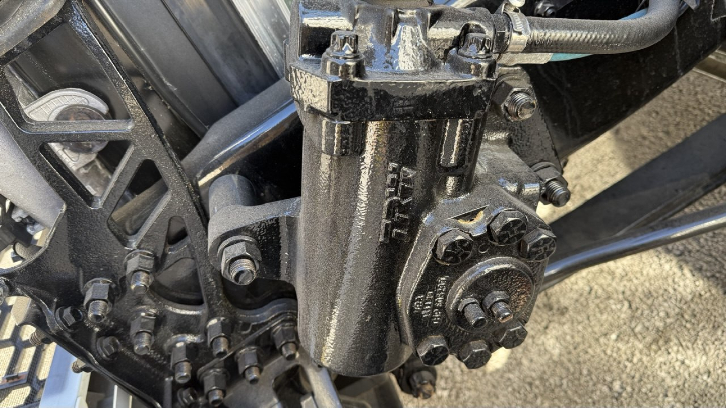 Valve/actuator assembly and hydraulic components on a Volvo VNR truck showing a hydraulic pump with fittings and bolts