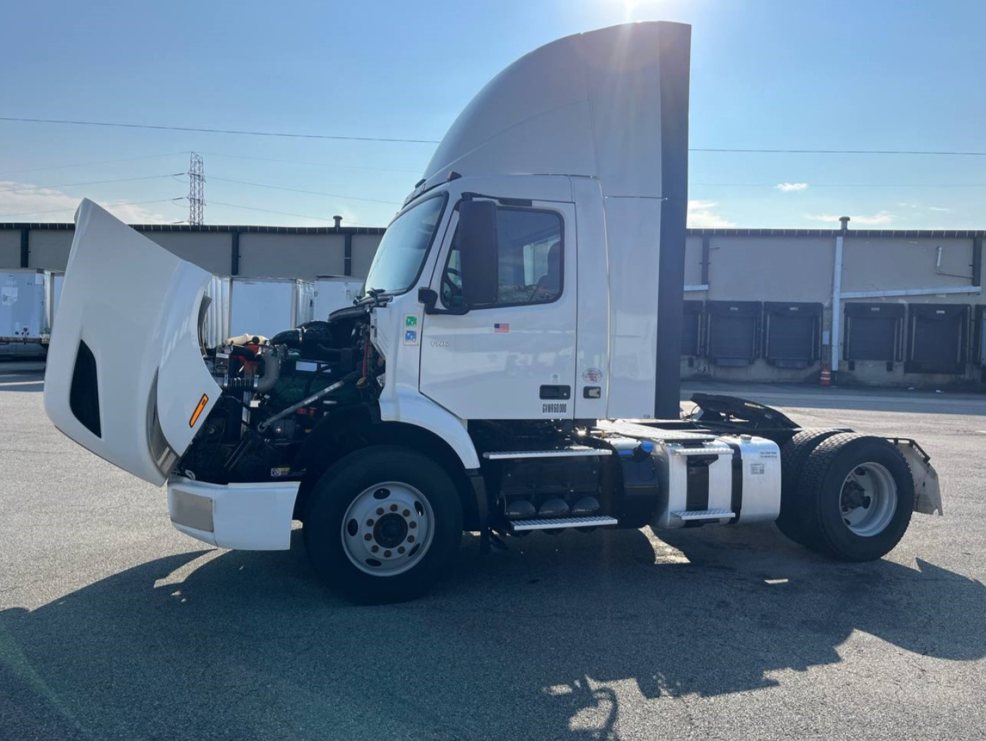 Volvo VNR300 4x2 single axle day cab with hood open showing engine compartment and side view of cab.