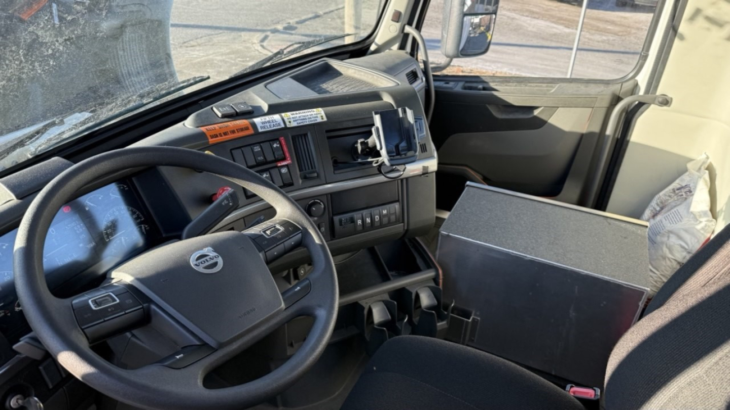 Volvo VNR300 day cab dashboard and steering wheel view showing driver seat and instrument cluster.