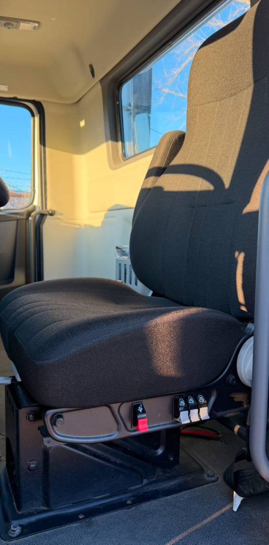 Volvo VNR300 day cab interior showing driver seat and base controls with window and doorway in view