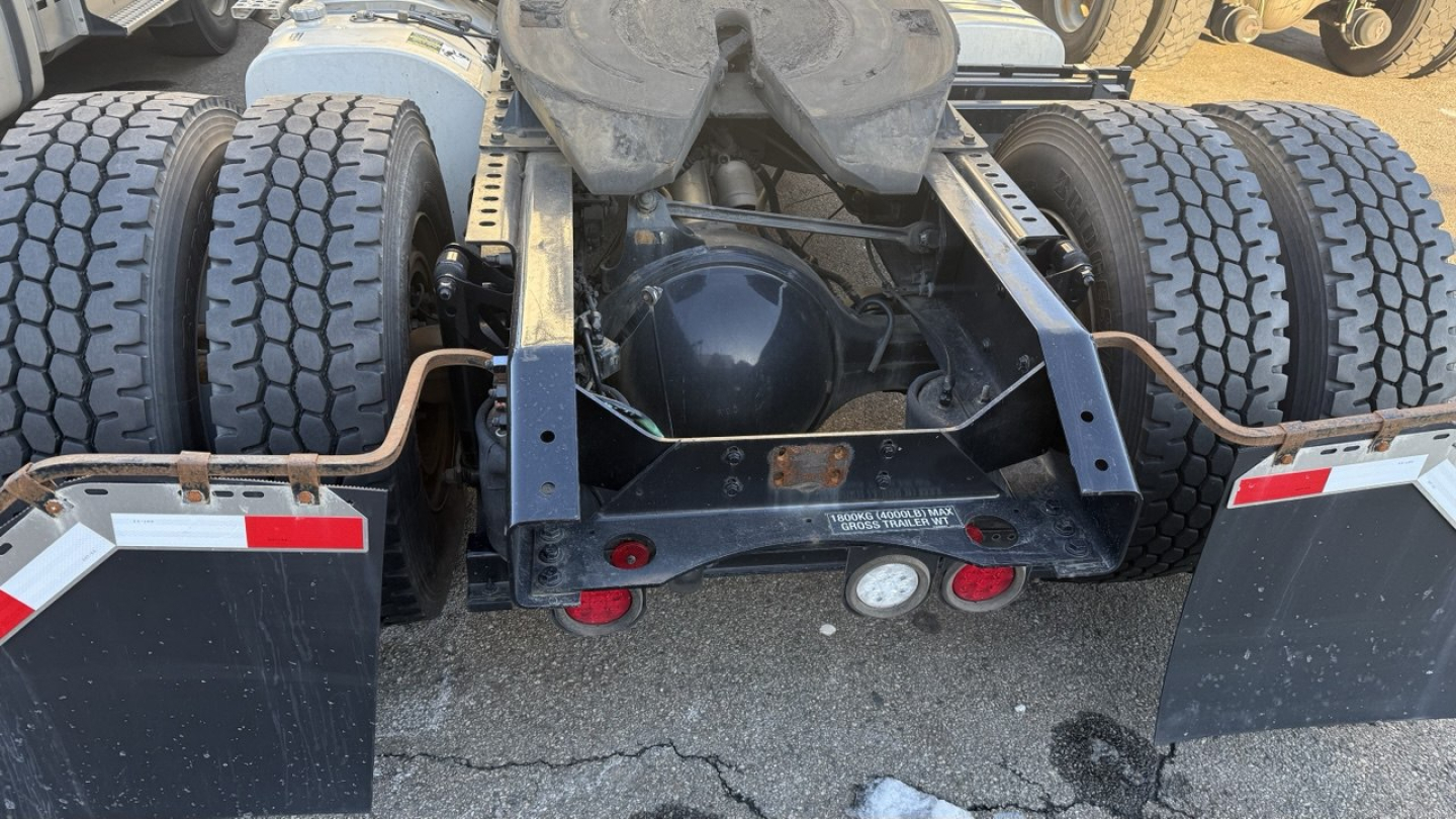 Rear view of a Volvo VNR300 truck drivetrain showing dual rear axles with heavy-duty tires, frame, and rear hydraulic components.
