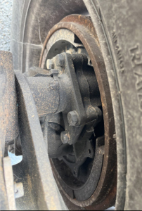 Wheel hub and suspension component near tire showing bolts and bearing area.