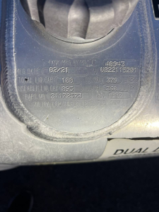 Engine bay label showing tank info: MFG DATE 02/21, TOT. LNG CAP 150D, MFG 2021? plus serial numbers and DEF label. Circular cap area with embossed text.