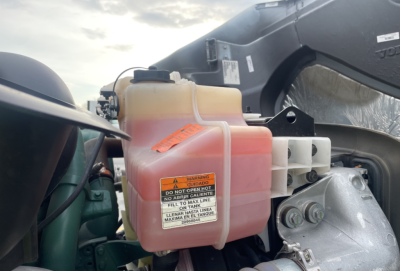 Reservoir with pink coolant visible on 2022 Volvo VNR300 4x2 Day Cab engine bay side