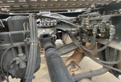Volvo VNR300 4x2 single axle day cab chassis view showing drivetrain linkage, hoses, and rear transmission area with various fittings.