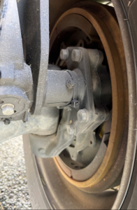 Volvo VNR300 4x2 day cab front axle showing brake rotor, caliper, and wheel hub in view.