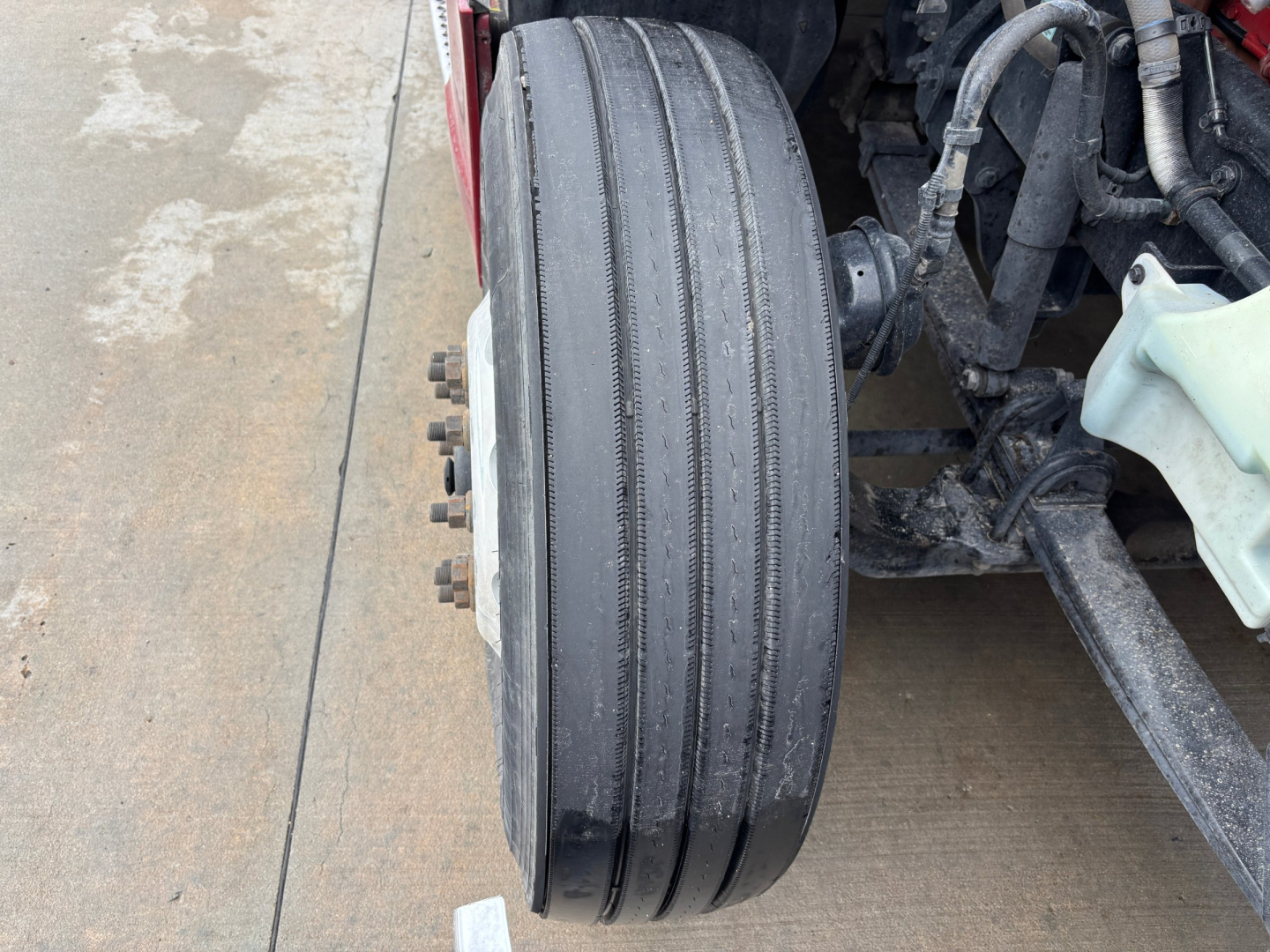 Kenworth T680 wheel and front suspension area showing dual rear axles? image with front tire, hub, and nearby components; no labels readable