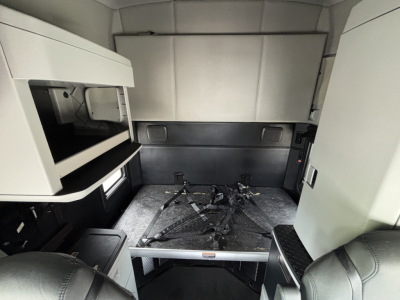Kenworth T680 sleeper cab interior showing storage shelves and bunk area with mounting frame for sleeper bed and seat in view.