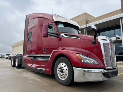 Kenworth T680 tractor in red, side view showing aerodynamic cab, front grille, chrome bumper, dual rear fenders, and large mirrors.
