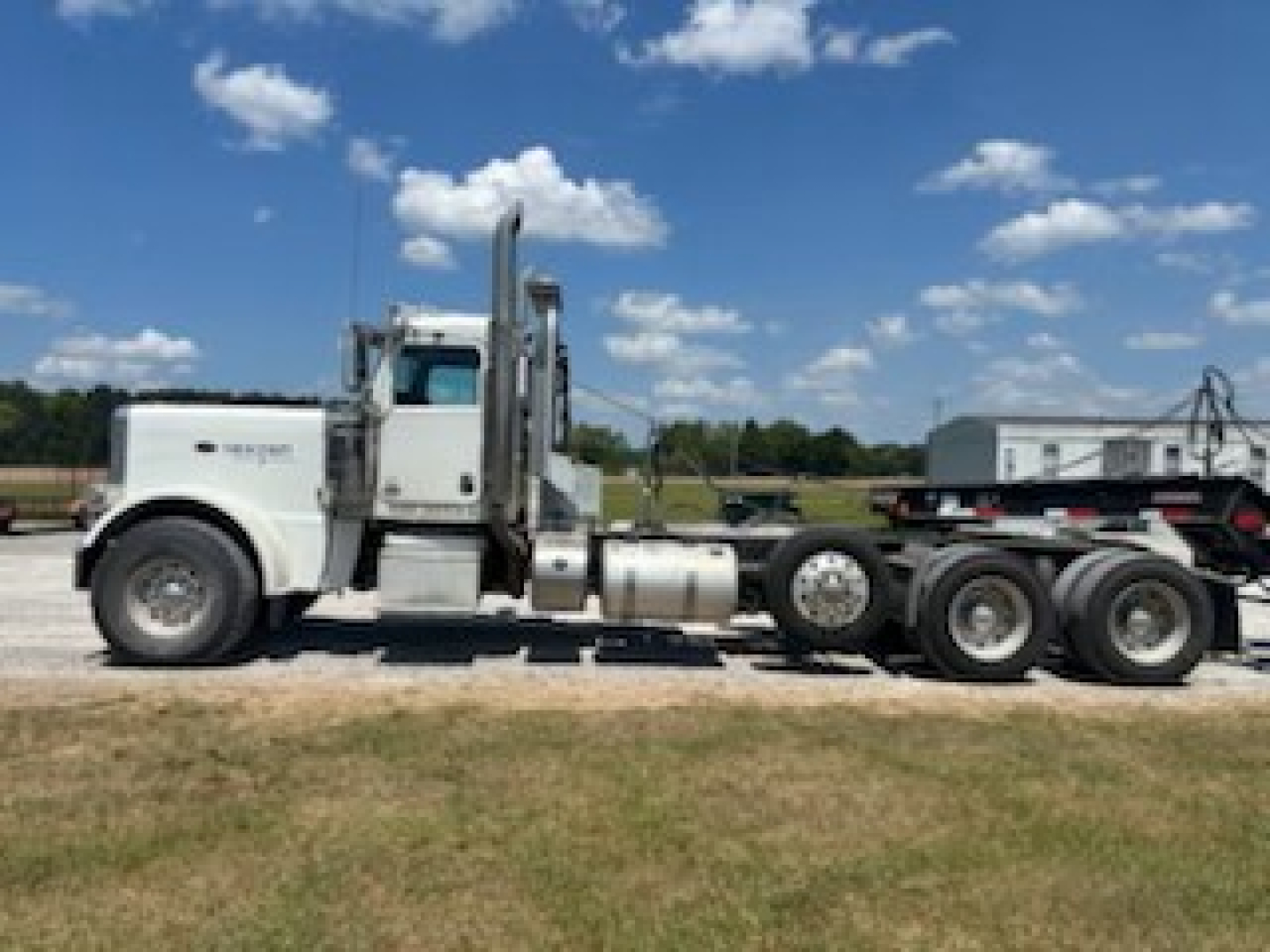Peterbilt 389 day cab truck side view showing cab, exhaust stacks, and rear axles.