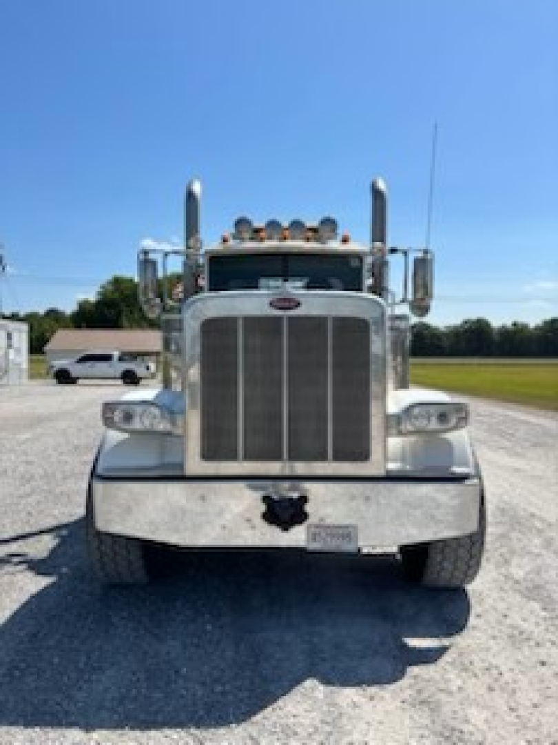 Peterbilt 389 front view showing large grille, dual air intakes, chrome bumper, and tall exhaust stacks.