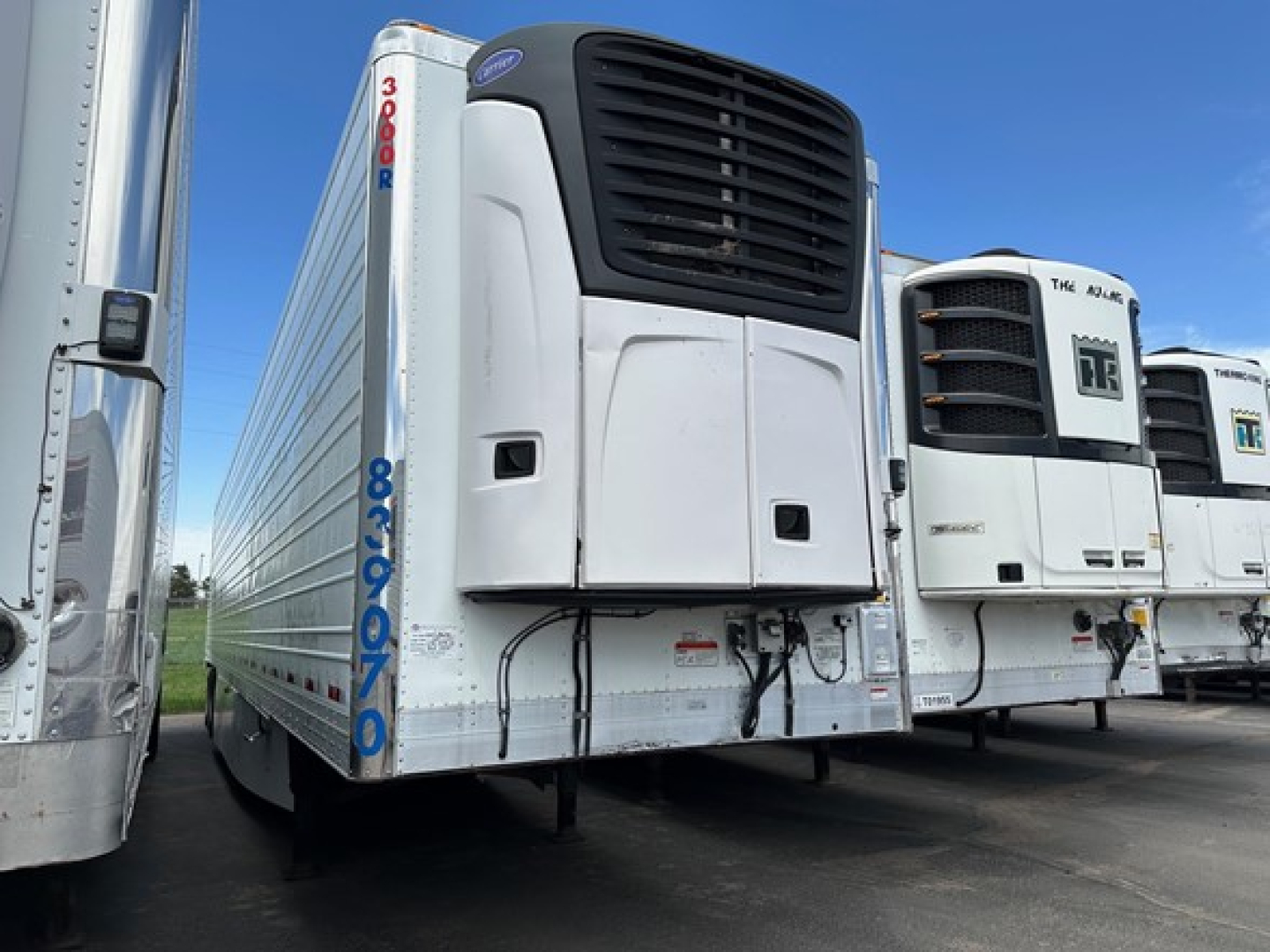 Utility 3000R trailer with refrigeration unit in front showing model badge and vertical blue stock numbers.