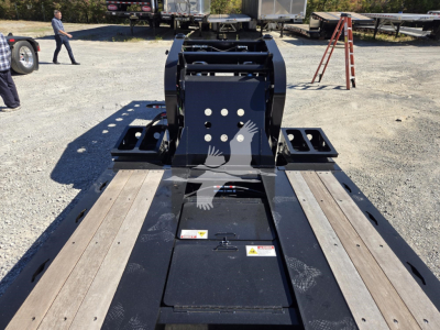 Trailer hitch area of a Fontaine 55 Lcc hydraulic flip lowboy trailer showing deck with wooden planks and hydraulic flip mechanism.