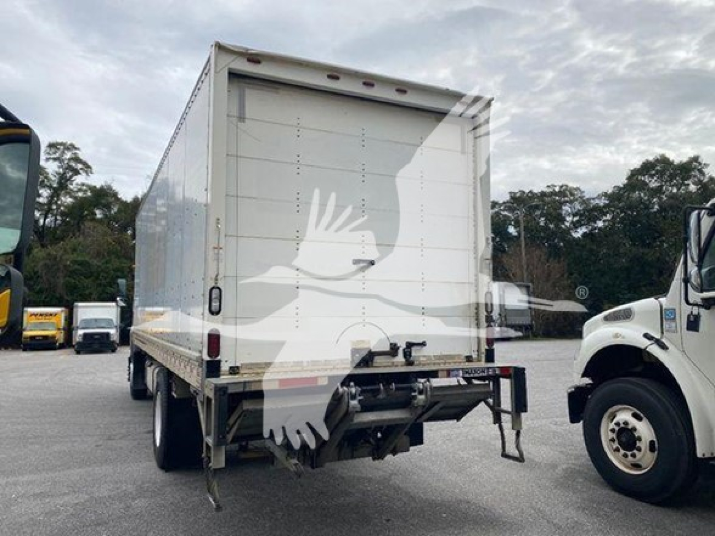 Isuzu box truck rear view showing back doors and undercarriage hardware. Visible text not legible due to watermark.