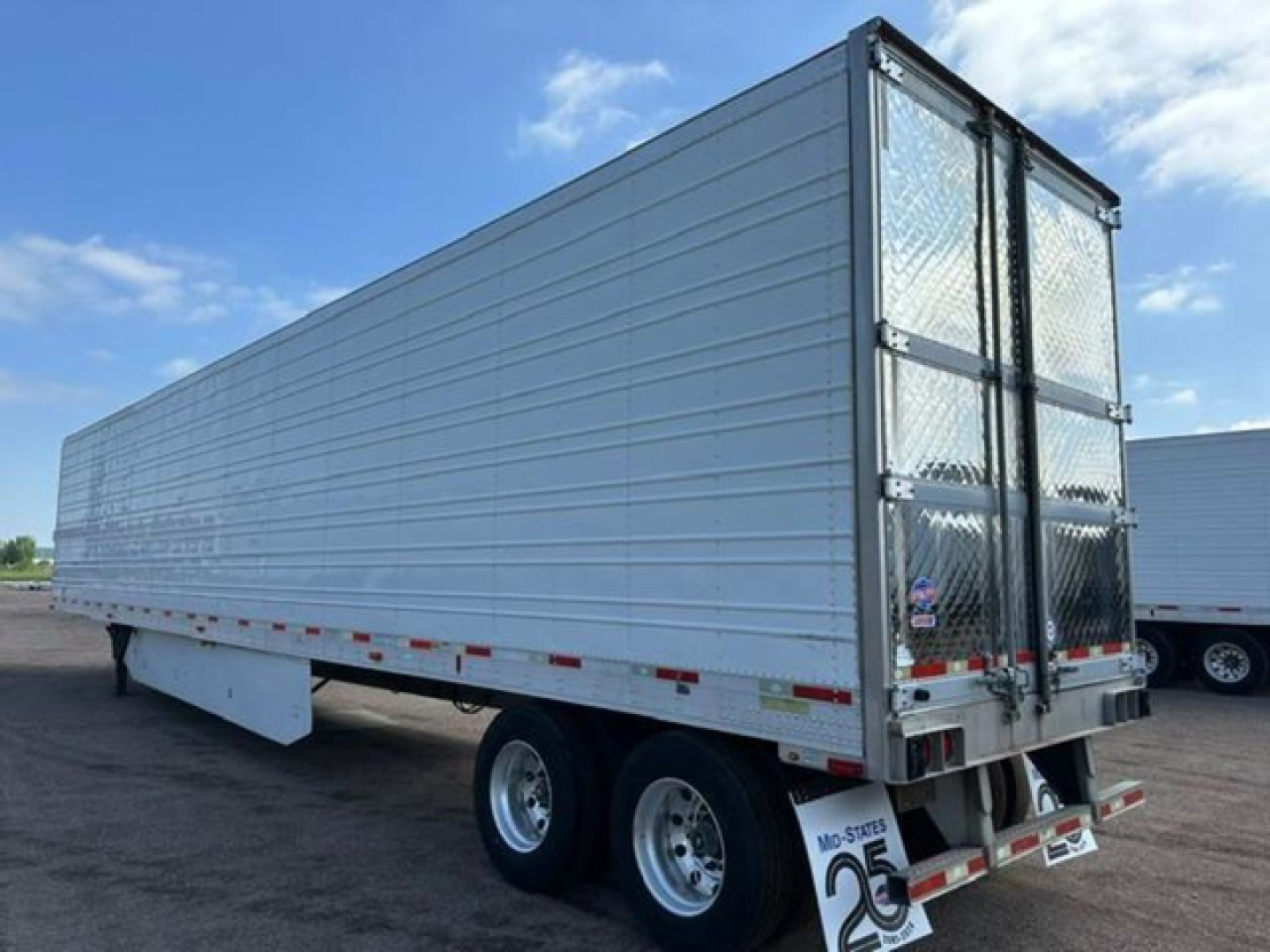 Trailer side and rear showing a refrigerated utility trailer with silver aluminum sides and diamond plate rear doors.