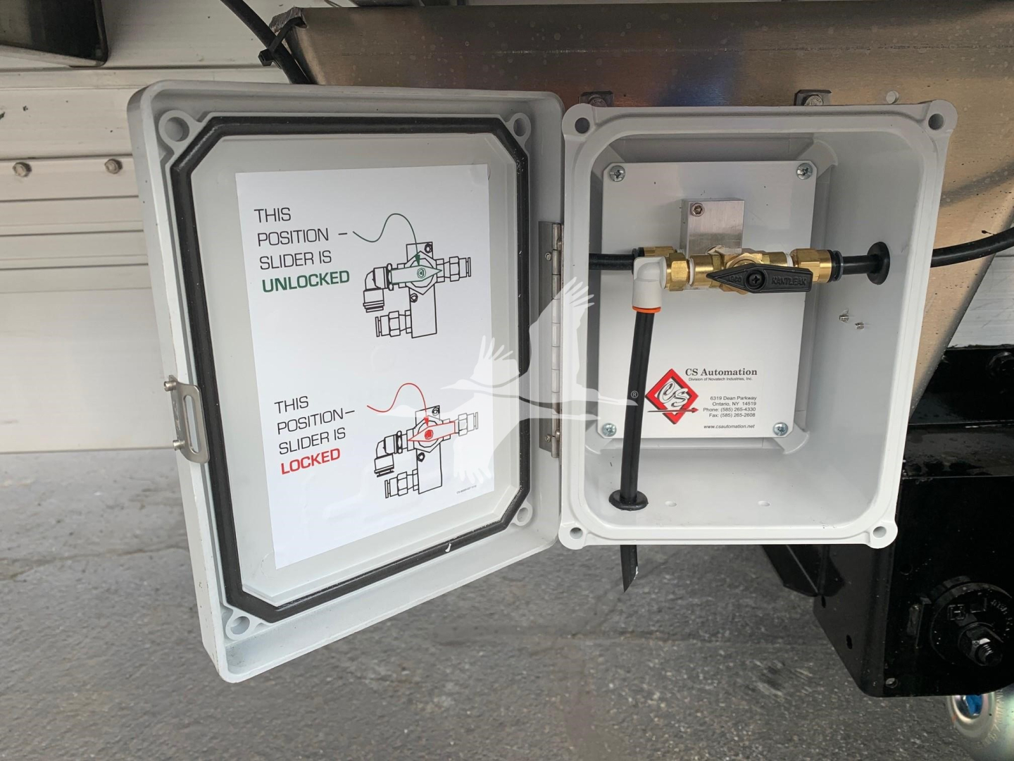 Trailer hitch area showing a CNF electrical box and a valve with a white label. The left door shows a diagram with green and red text about position slider unlocked/locked.